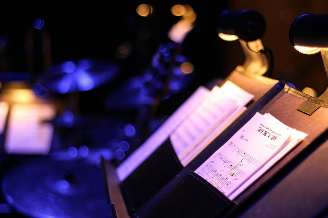 Stack of paper documents and a pen on a wooden desk
